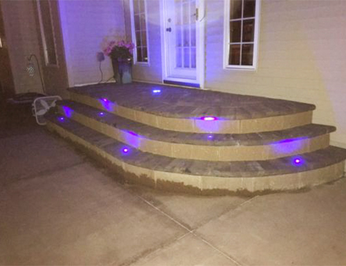 Patio pavers with stairs that is lighted.